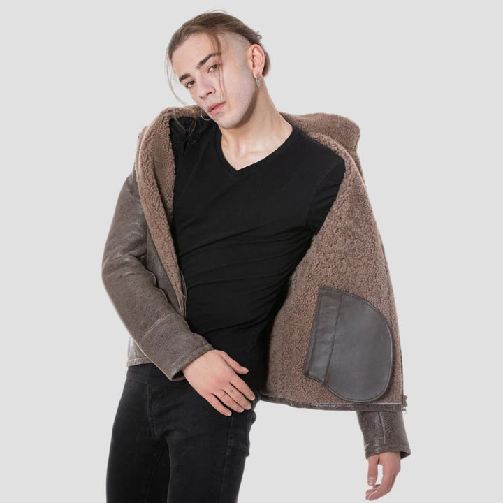 Men’s brown leather jacket with curly faux fur lining for warmth.